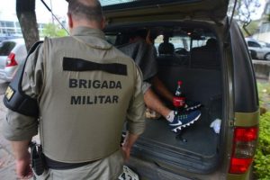 Um preso segue em viatura da Brigada Militar na frente da 2ª DPPA | Foto: Guilherme Testa